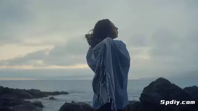 一个女孩在海边用毛巾擦干头发。视频素材