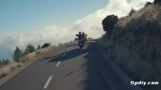 两名骑自行车的人正驶过道路上的上坡弯道视频素材