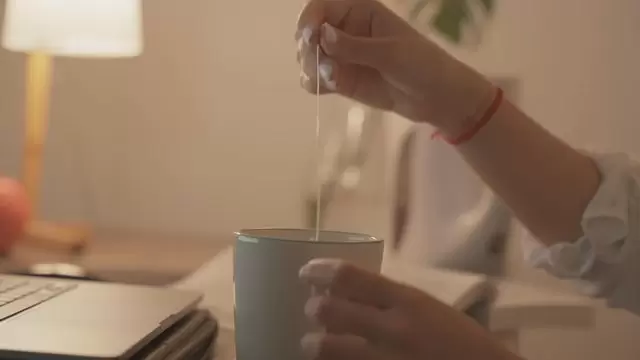 女人在她的家庭办公室喝茶视频素材插图