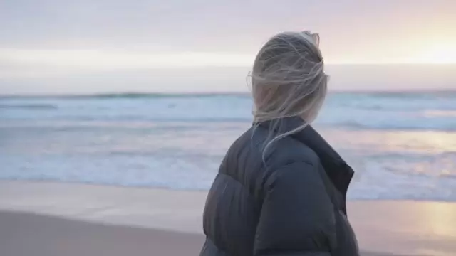 金发女孩在日落时拍摄海滩照片视频素材插图