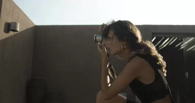 女摄影师蹲下来拍摄照片视频素材插图