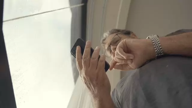 一个男人小心地使用他的智能手机视频素材插图