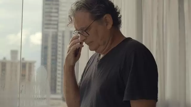 一个老人在他的苹果手机上说话视频素材插图