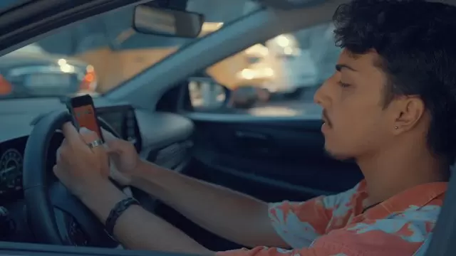 一名少年坐在车里在手机上发信息视频素材插图