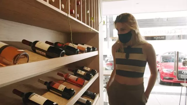 女人在葡萄酒庄园选择一瓶酒视频素材插图
