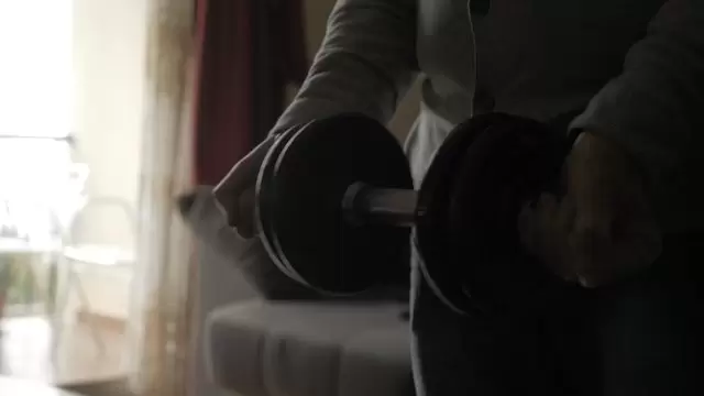 一个老人在家举杠铃锻炼视频素材插图