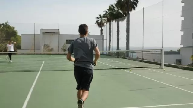 男子拿起网球捡球视频素材插图