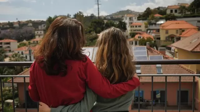妈妈和女儿站在阳台上拥抱视频素材插图