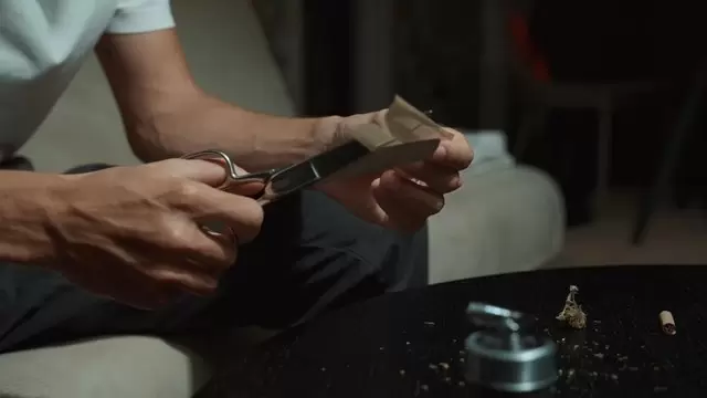 一个切割烟草卷纸的人视频素材插图