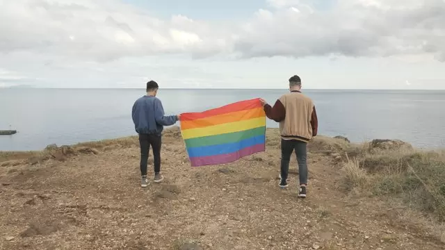 同性恋夫妇举着骄傲的旗帜航拍视频素材插图