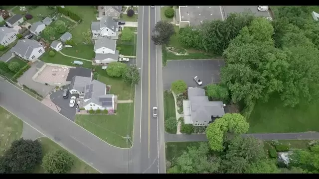 在郊区房屋附近开车航拍视频素材插图