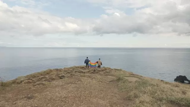 两个男人带着骄傲的旗帜行走航拍视频素材插图