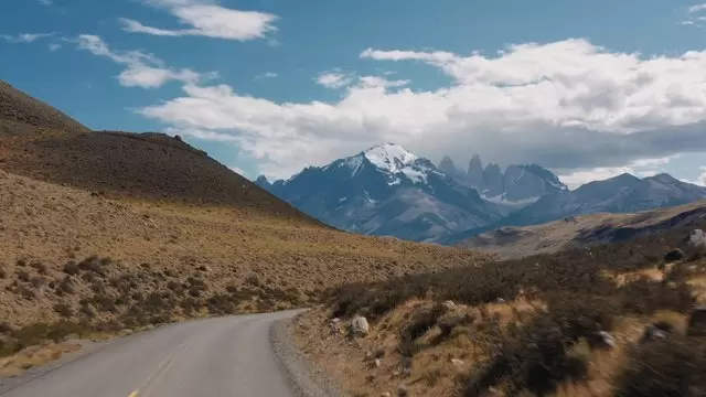 穿过山丘的道路和雪山航拍视频素材插图