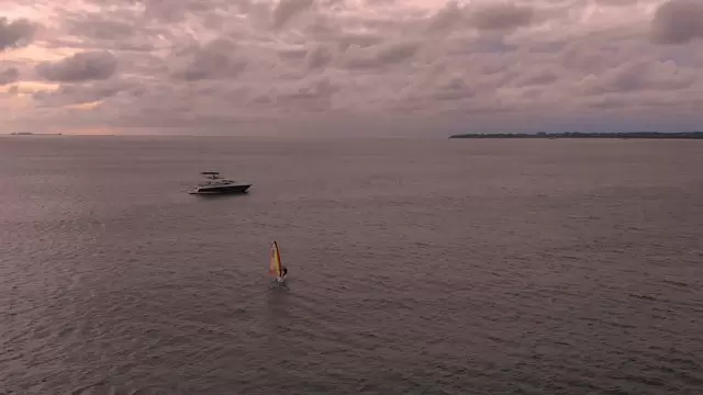 风帆冲浪者和海洋中的游艇航拍视频素材插图
